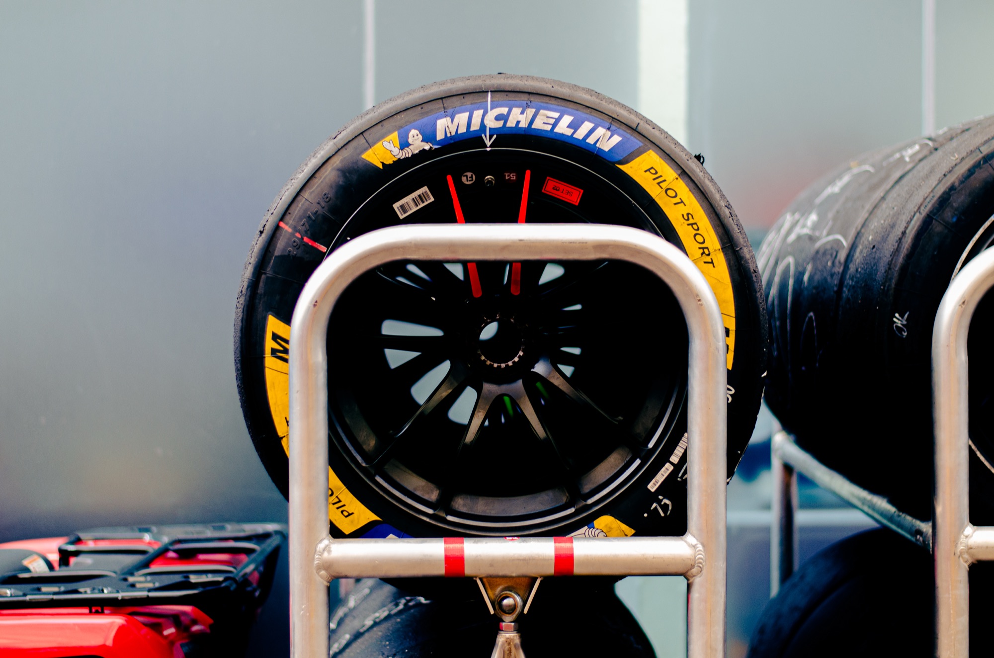 Pneu slick Michelin Pilot Sport montado no carrinho, com mais jogos atrás nos boxes